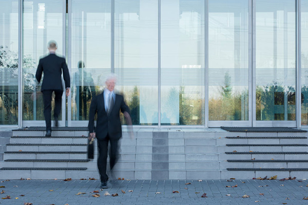 Two employees passing through the office's door